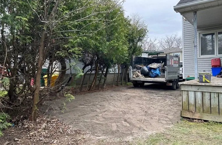 Truck containing junk parked next to house